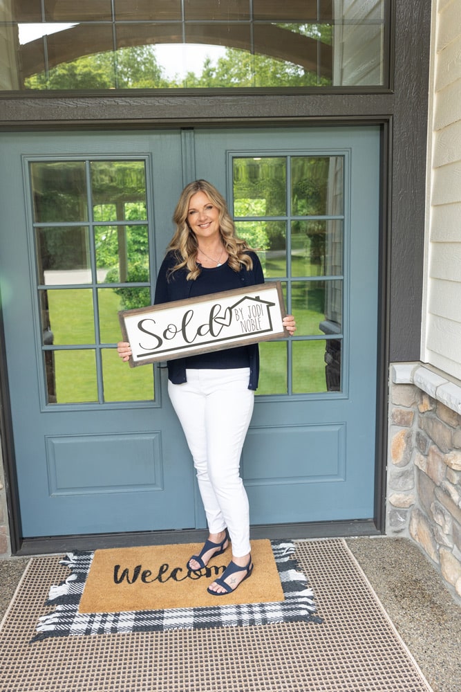 jodi with sold sign in front of home
